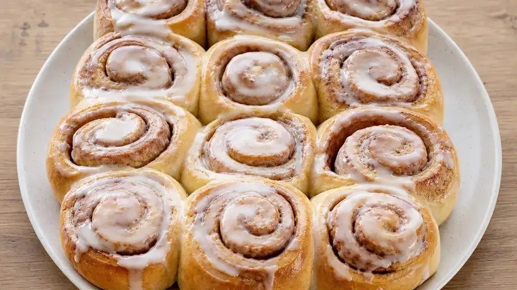 Luchtige kaneelbroodjes met glazuur op een bord