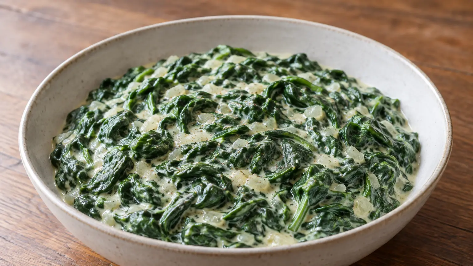 Tender spinach leaves in a cream sauce in a small bowl