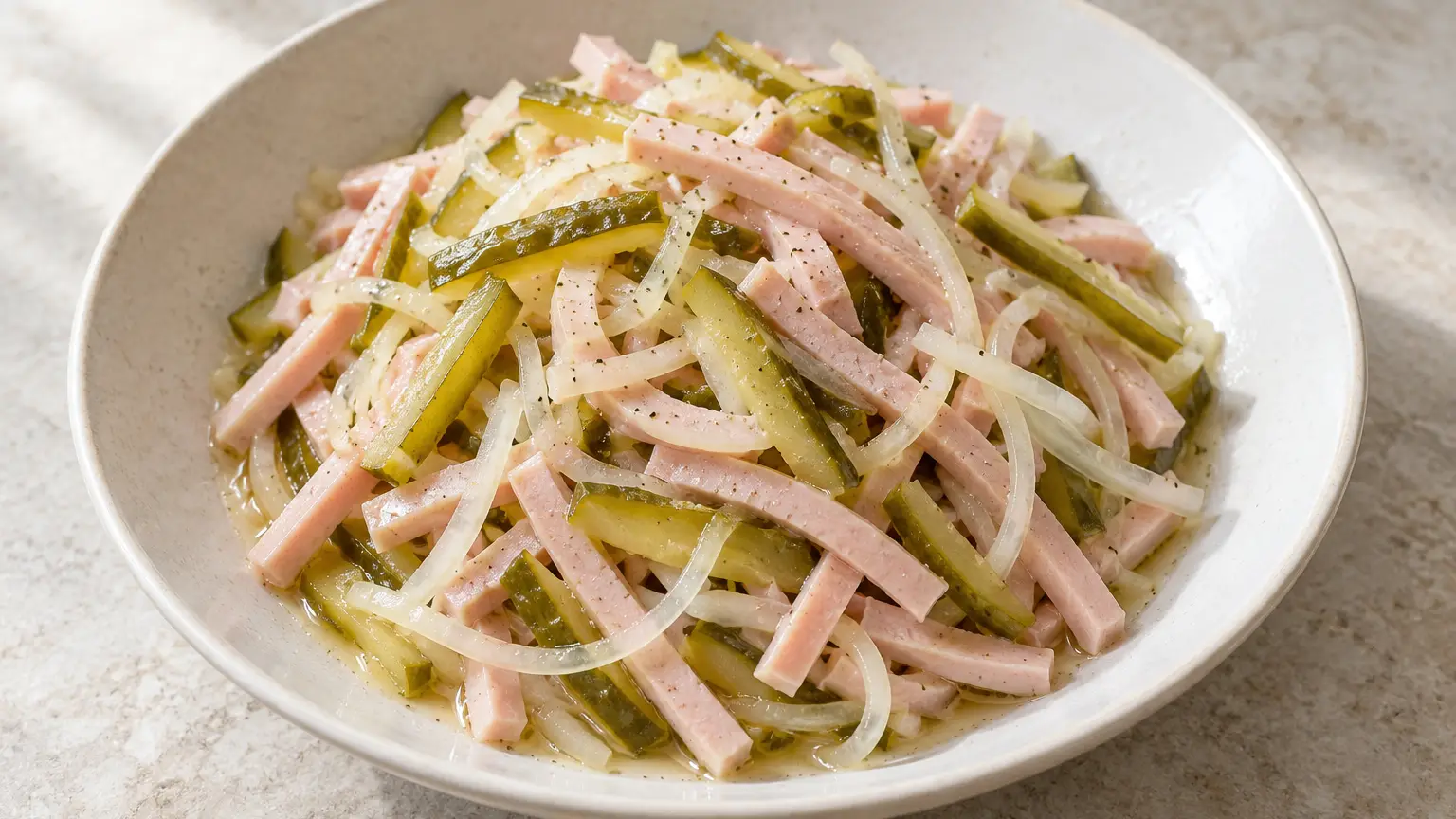 Wurstsalat with thin cooked sausage strips, vinegar pickles, and onion in a light dressing
