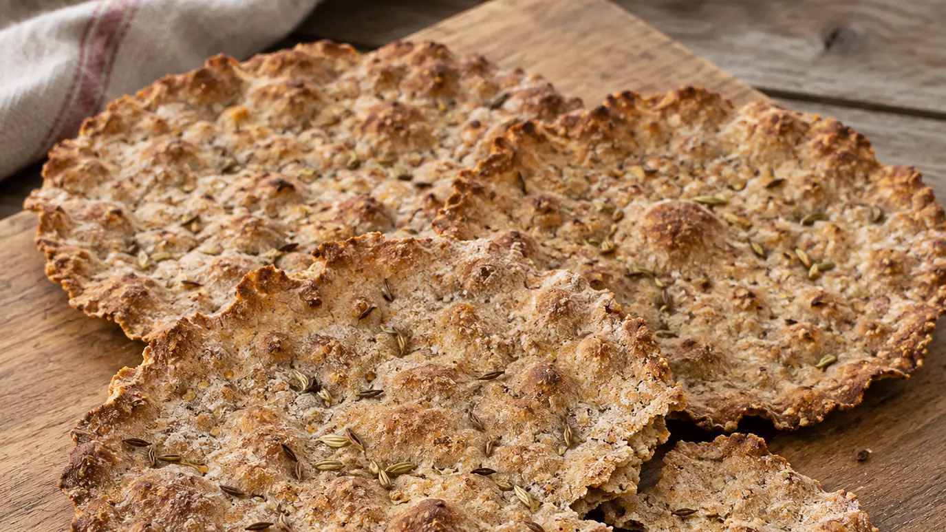 Dunne, gebruinde Schüttelbrote met onregelmatige randen, zichtbare karwij en venkelzaad